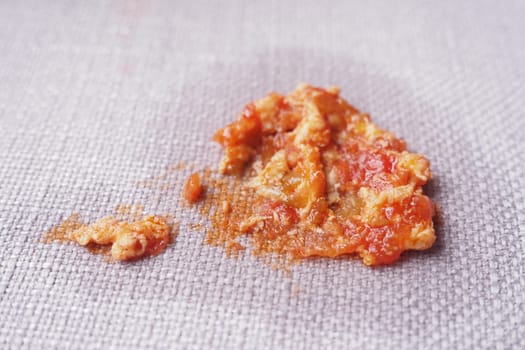 A messy spill of tomato sauce showing chunks and smooth texture.
