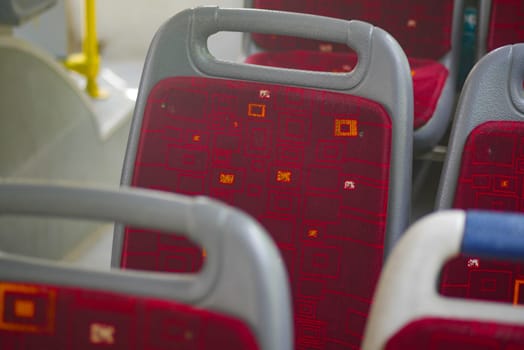 Empty seats on a city bus conveying a quiet, urban atmosphere.