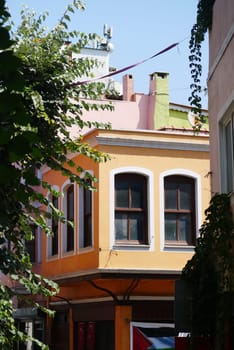 Brightly painted buildings line a narrow alley under clear skies.