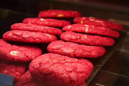 Delicious red cookies with white chocolate chips are neatly arranged.