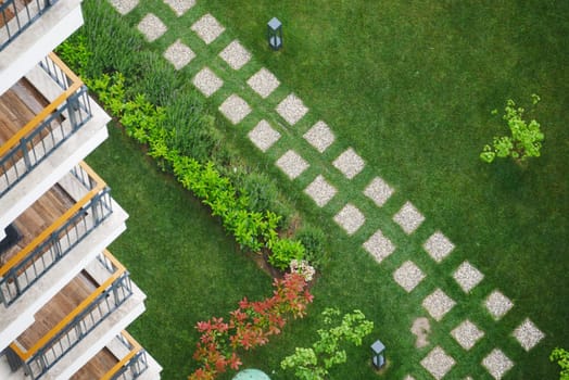 Aerial view of a landscaped garden with paths and modern architecture.