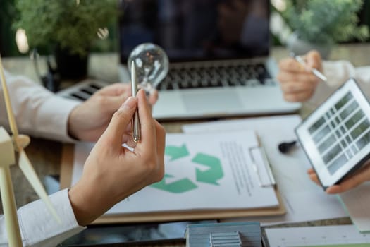 A professional showcases a technological tool during a project meeting, focusing on eco-friendly solutions and planning for sustainable energy initiatives.