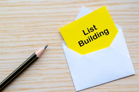 List Building text on yellow notepad inside a white envelope. Making money online concept.