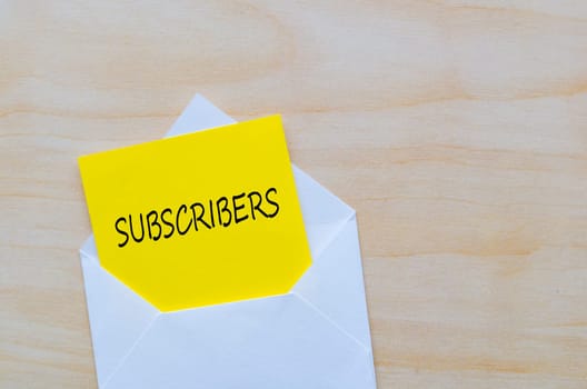 Subscribers text on yellow notepad inside a white envelope. Making money online concept.