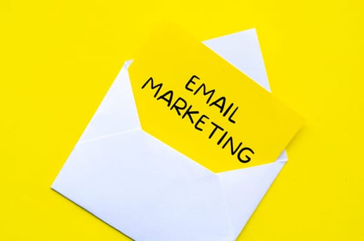 Email marketing text on yellow notepad inside a white envelope. Making money online concept.