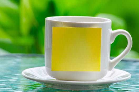 White cup with empty sticky notepad. Copy space concept.