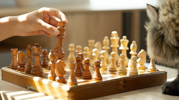 Hand moves a wooden chess piece during a game. Strategy, decision making and board games concept.