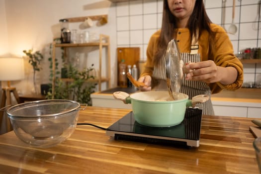 Young woman in an apron cooking a simple meal in her home kitchen.