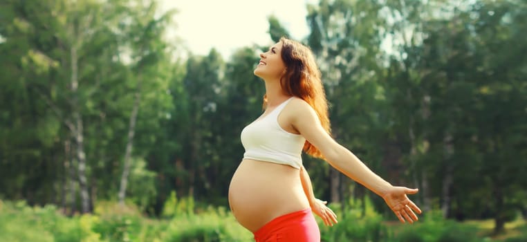 Maternity, pregnancy, happy young pregnant woman with big belly enjoying warm sunny day in summer park