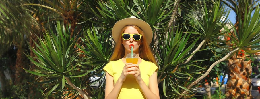 Summer vacation, tourism, happy young woman drinking fresh juice in straw tourist hat standing on the beach with palm trees