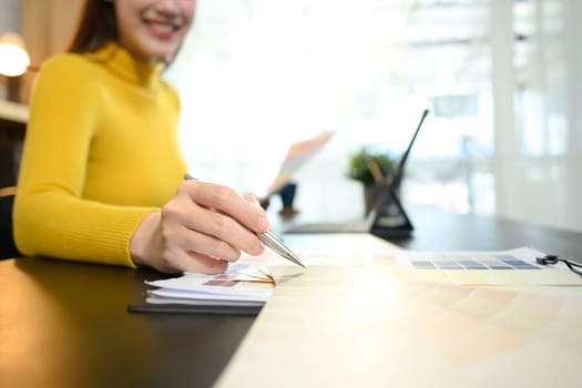 Graphic designer working with color palettes in a modern office.