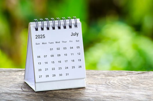 July 2025 white table calendar with outdoor background. Calendar concept.