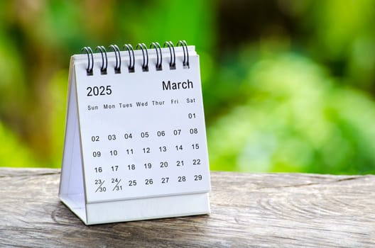 March 2025 white table calendar with outdoor background. Calendar concept.