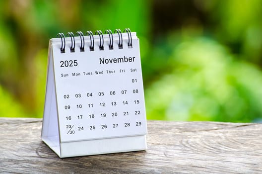 November 2025 white table calendar with outdoor background. Calendar concept.