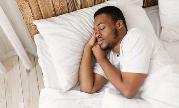 African American Man Sleeping Peacefully Resting With Eyes Closed Lying In Comfortable Bed In Bedroom At Home. Recreation, Healthy Male Sleep, Bedtime Napping Concept. Empty Space For Text