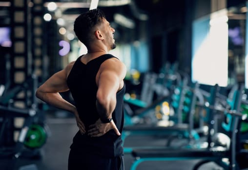 Portrait Of Young Arab Bodybuilder Suffering Lower Back Pain At Gym, Upset Middle Eastern Male Athlete Rubbing Painful Sore Zone After Getting Sport Injury, Having Lumbar Spine Ache, Copy Space