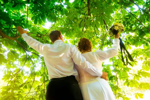 Wedding. stylish bride and groom in park are holding Bridal bouquet of flowers in brown tones with a ribbon