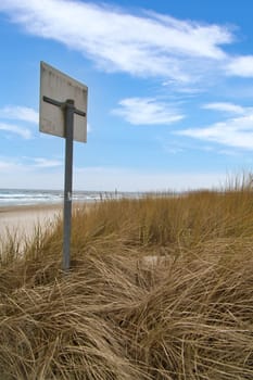 View over the dunes on the island of Usedom to the Baltic Sea. Dune grass, bathing sign and white sand. Nature photo from the coast
