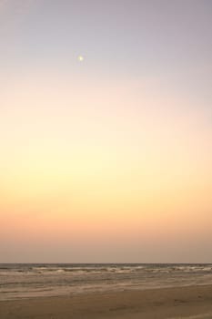 View over the beach on the coast of Usedom at sunset. The moon is in the sky. Landscape shot of the sea