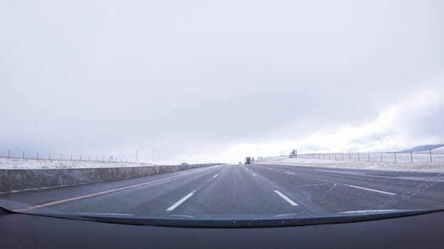 The open highway invites a peaceful drive, with snow-clad pines lining I-25 as the journey continues from Denver towards Colorado Springs on a snowy day.