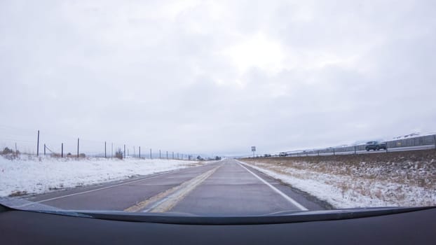 The open highway invites a peaceful drive, with snow-clad pines lining I-25 as the journey continues from Denver towards Colorado Springs on a snowy day.