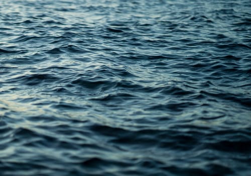 View of water surface with small ripples, waves, seascape without people, wildlife with endless blue ocean closeup.