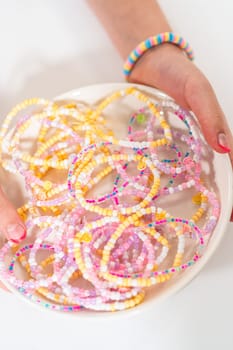 Little girl's charming bracelets adorned with clay and sea beads.