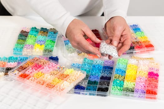 Assorted clay bead boxes neatly arranged on a white table, awaiting a creative kids' craft project.