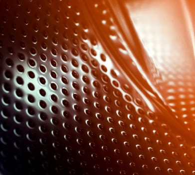 Modern abstract background with shiny metal, distorted black carbon fiber with dark dots, dents, surfaces with angles and curves, closeup view with a copy space.