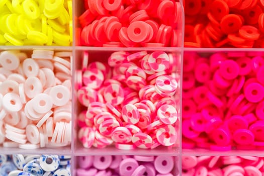Assorted clay bead boxes neatly arranged on a white table, awaiting a creative kids' craft project.