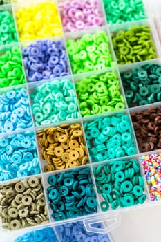 Assorted clay bead boxes neatly arranged on a white table, awaiting a creative kids' craft project.