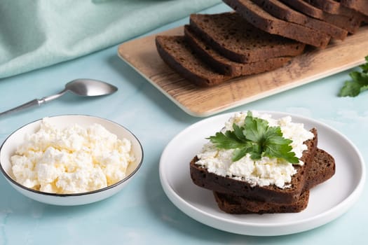 Delicious rye bread with cottage cheese and parsley on a cozy kitchen table.