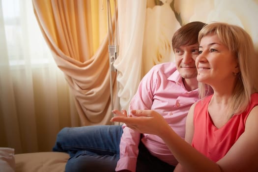 A couple in their fifties enjoys a romantic photoshoot at a hotel, celebrating their love with smiles and flowers.