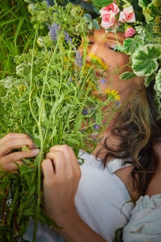 Slavic plump chubby girl in long white dress on the feast of Ivan Kupala with flowers and water in a river or lake on summer evening
