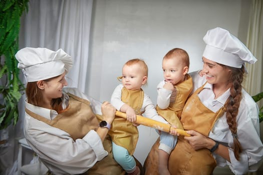 A families enjoys a fun cooking session, playfully covered in flour while engaging with little ones in warm kitchen. Mothers and children having fun