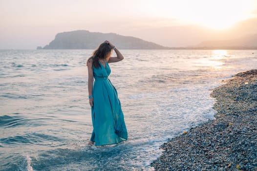 A woman in a flowing green dress poses on a pier by the sea at sunset, with a Turkey flag waving in the background.