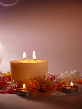 Celebration of Diwali or Deepavali holiday in India with candles and flowers in the evening at night close-up. Hindus celebrate the festival of lights, vertical