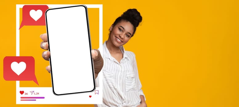 A confident influencer holds a blank smartphone against a vibrant yellow background. She interacts with her online audience, representing modern social media engagement and communication.