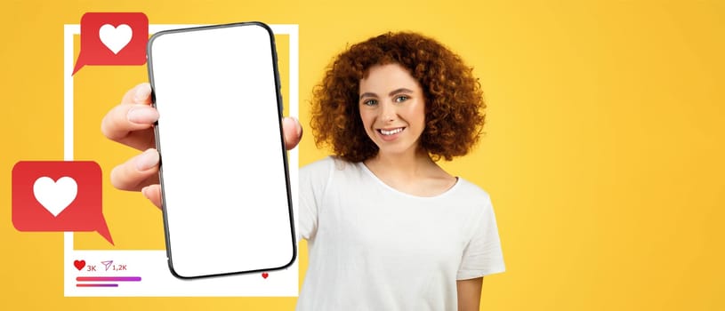 A cheerful influencer with curly hair holds a smartphone against a bright yellow background. The screen is blank, perfect for showcasing social media interactions like likes and messages.
