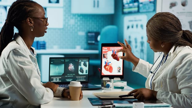 Medical office scene of a doctor and patient evaluating cardiology test results, focusing on diagnostics and preventive care in a professional environment. Health care industry. Camera A.