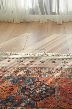 Soft sunlight casts shadows over a vibrant rug in a cozy room.