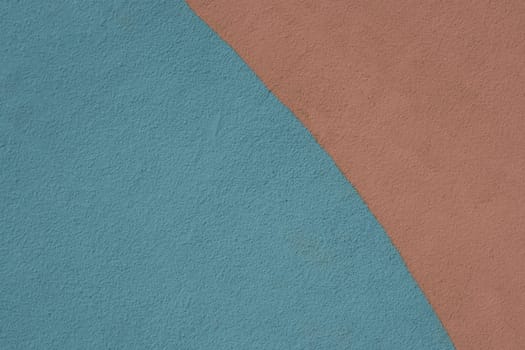 Close-up of a wall fragment painted blue and brown. Abstract texture for design.