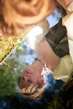 Fairy princess in a beautiful dress, laying on the forest floor, reflected in a mirror. Environmental friendliness and caring for nature