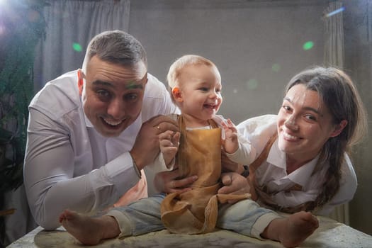 A family enjoys a fun cooking session, playfully covered in flour while engaging with their little ones in warm kitchen