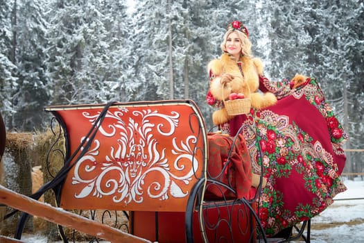 A girl in traditional Russian attire enjoys a winter photoshoot with a horse amidst a festive Maslenitsa celebration.