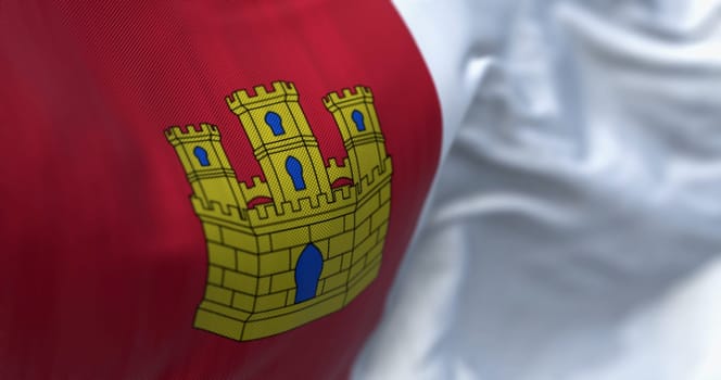 Castilla-La Mancha flag waving. Castilla-La Mancha is an autonomous community of Spain. Two squares: crimson red with a gold castle and white. 3d illustration render. Selective focus. Close-up