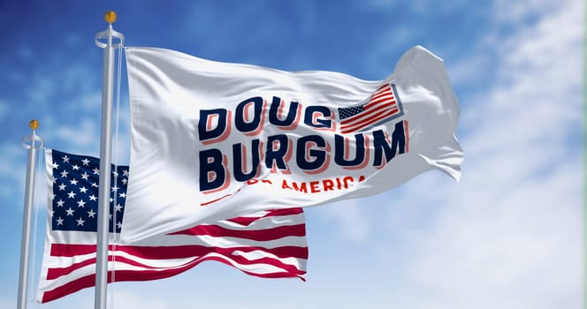 Arthut, US, June 2023: Flags of Doug Burgum election campaign and the national flag of the United States waving. 2024 US presidential elections. Illustrative editorial 3d illustration render