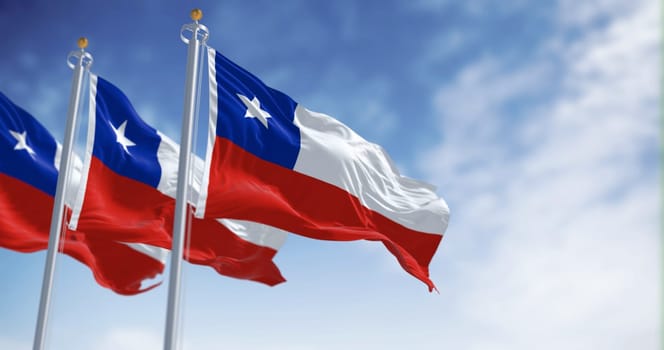 Chile national flags fluttering in the wind on a sunny day. The Chilean flag is red and white with a blue square and white 5-pointed star on the white band. 3d illustration render. Selective focus