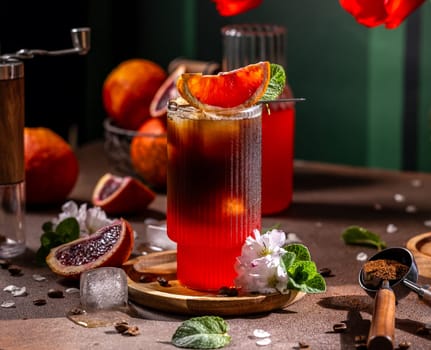 Glass of iced coffee infused with blood orange, decorated with mint leaves and orange slice, creating a vibrant and refreshing summer beverage