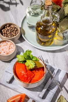 Delicious pickled tomatoes seasoned with herbs and spices, presented in a bowl, ready to be enjoyed